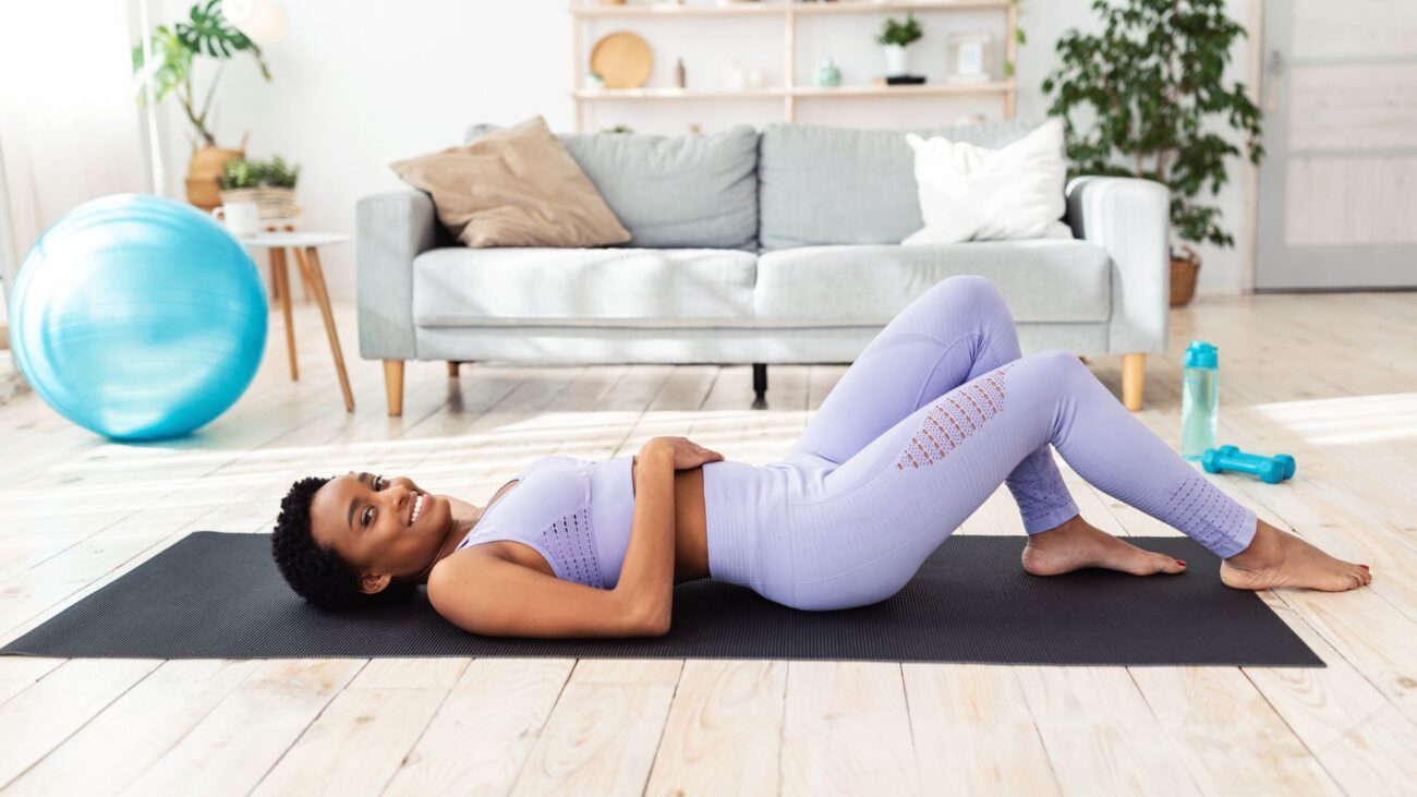 woman lying on her back on yoga mat