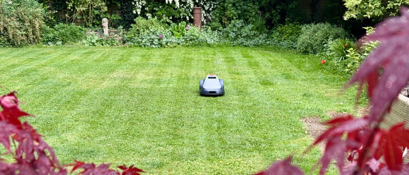 Eufy E15 robot lawn mower mowing in neat stripes on reviewer's lawn