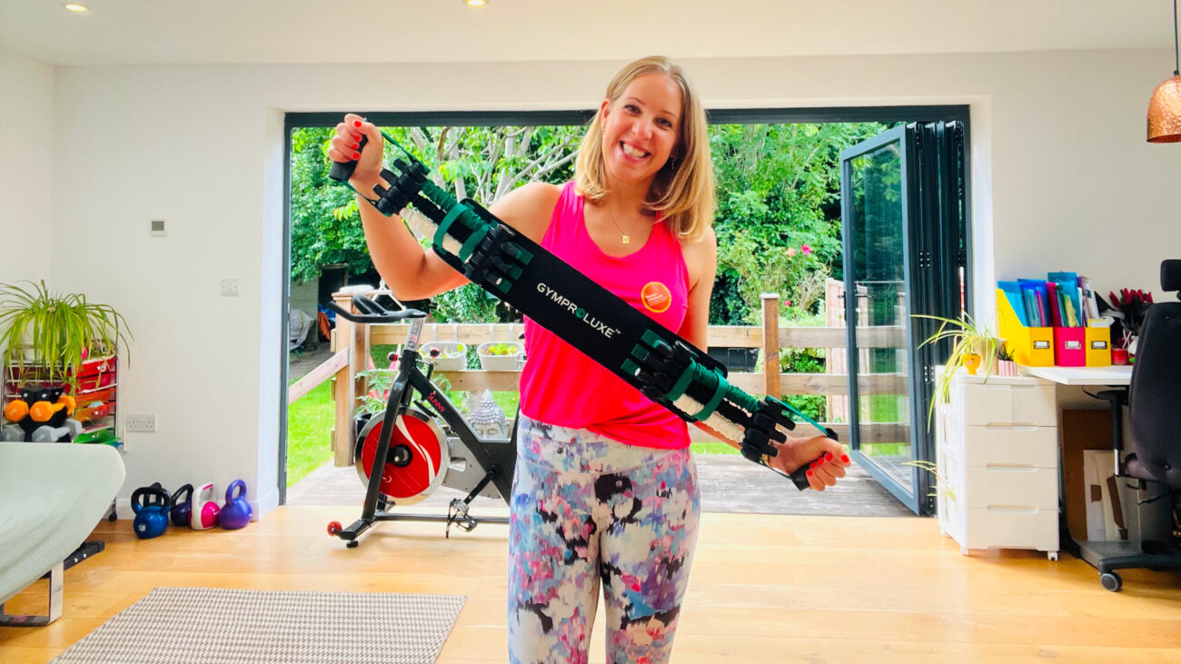 Smiling woman holds a thick belt with handles either end