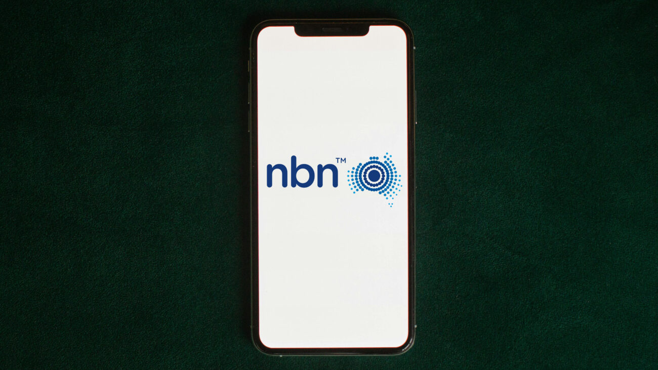 NBN logo on phone on dark green background