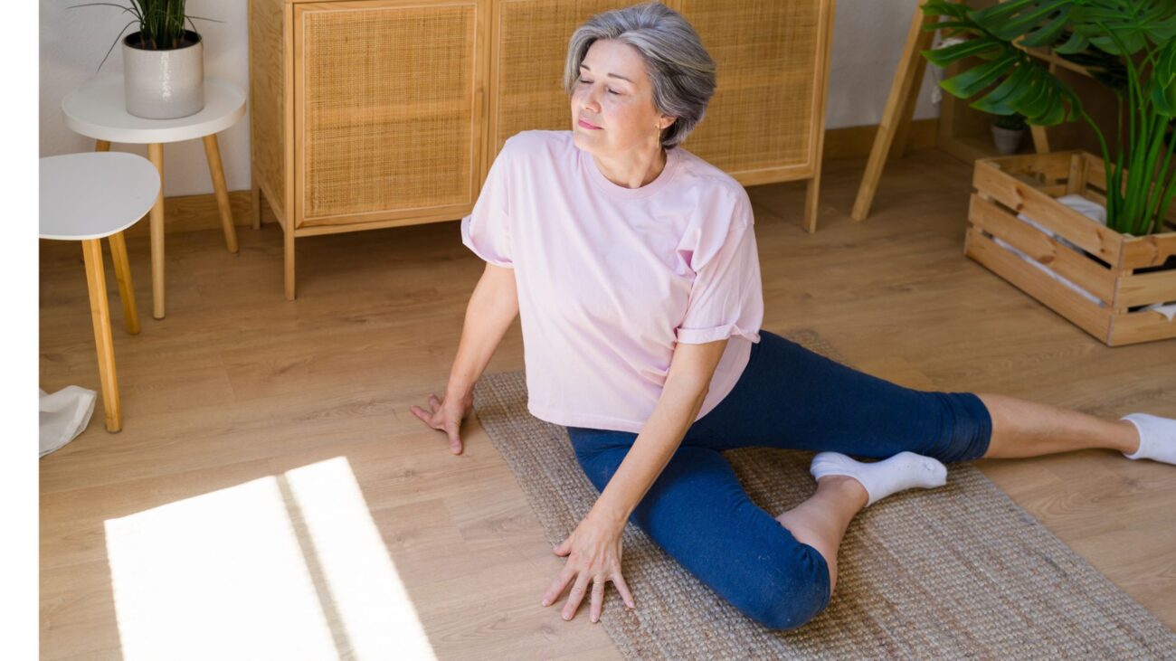 woman does a seated hip stretch on floor