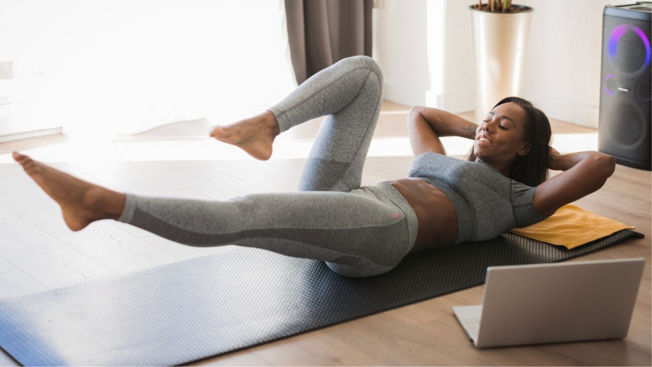 woman on back on yoga mat doing exercise