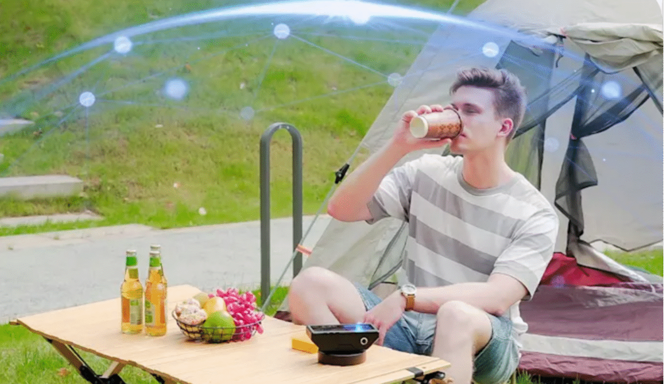 Photon Matrix pictured on a table outside with an illustrated defense matrix around it protecting a man drinking his coffee from mosquitoes