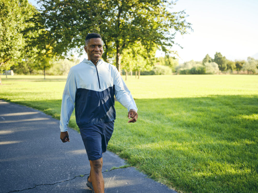 Man in activewear walking in sunny park