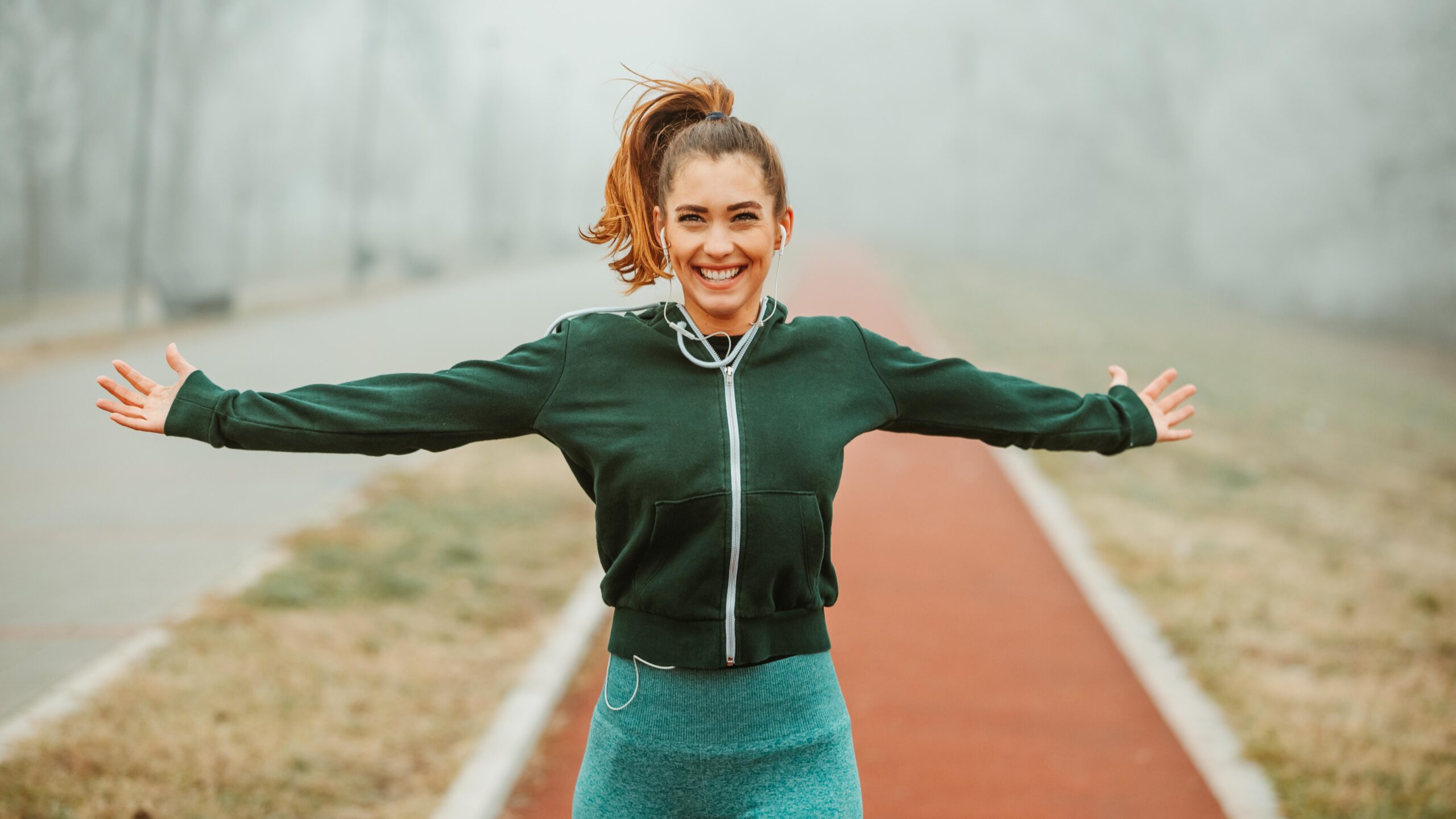a woman on a trail with arms outstretched