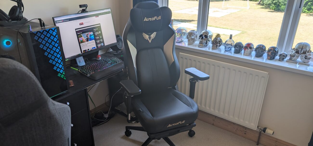 The AutoFull M6 Ultra gaming chair pictured in front of a desk with a gaming PC setup.