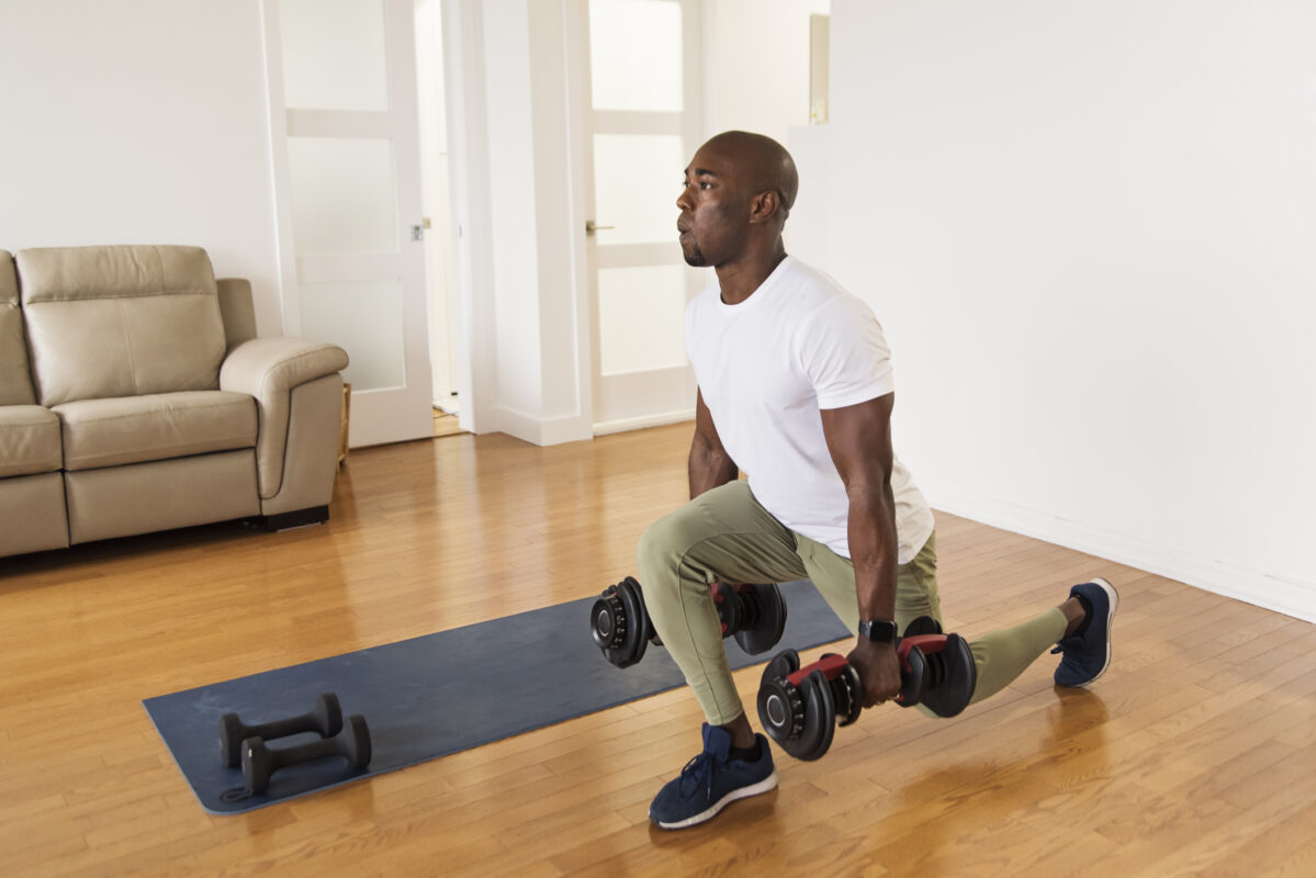 Man exercising with dumbbells in domestic setting