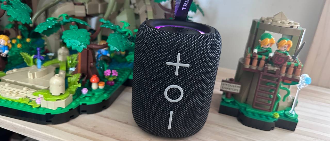 Tribit Stormbox Mini Plus Bluetooth speakers surrounded by Lego sculptures, on a wooden surface