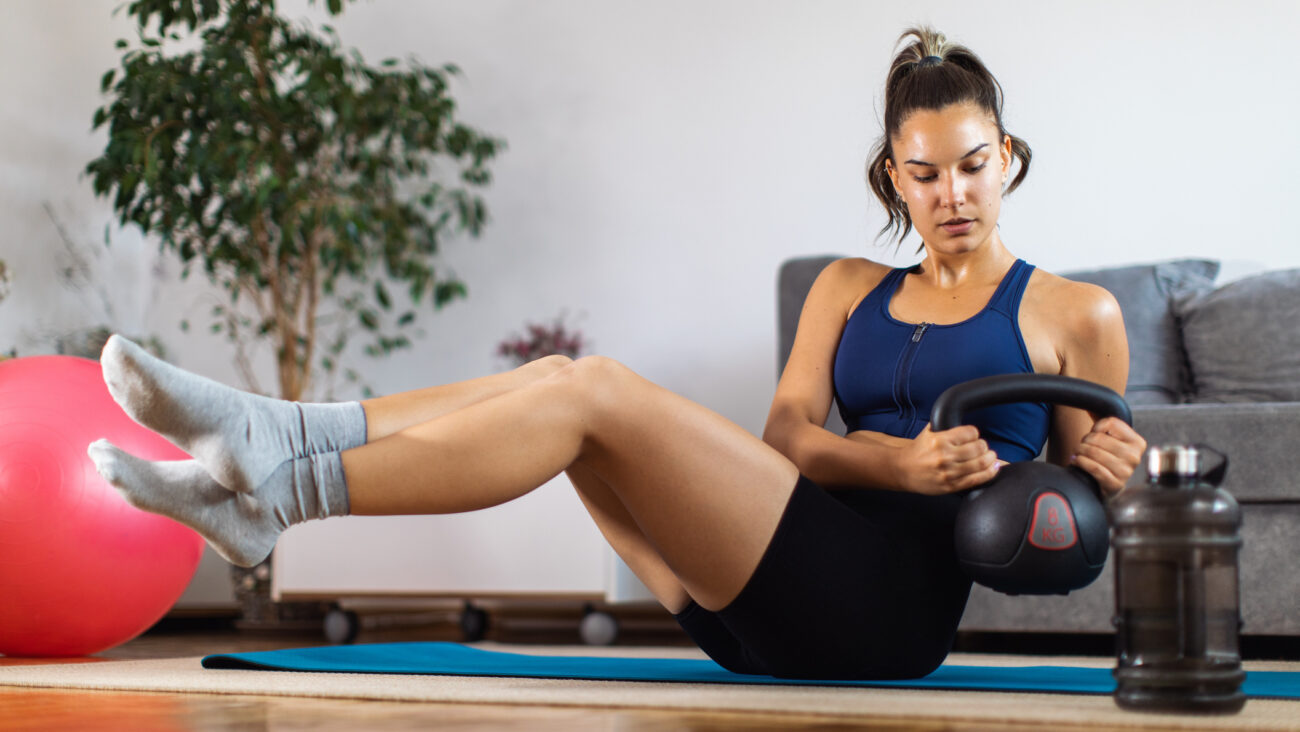 Woman exercising with kettlebell at home